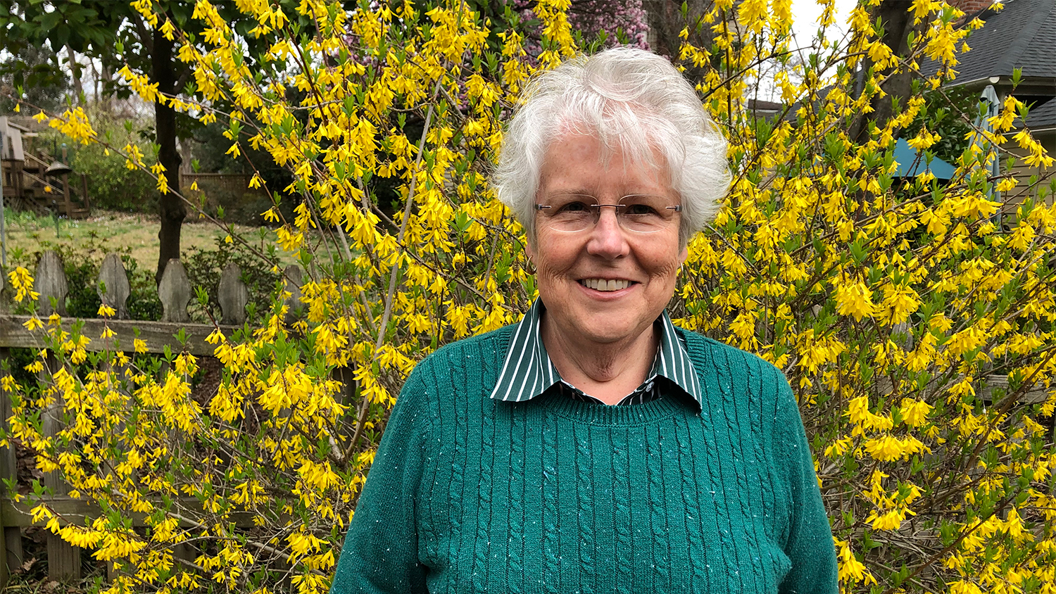 Mary smiles in front of yellow flowers - Women in Natural Resources: Forestry Professor Mary Watzin - Forestry and Environmental Resources NC State University