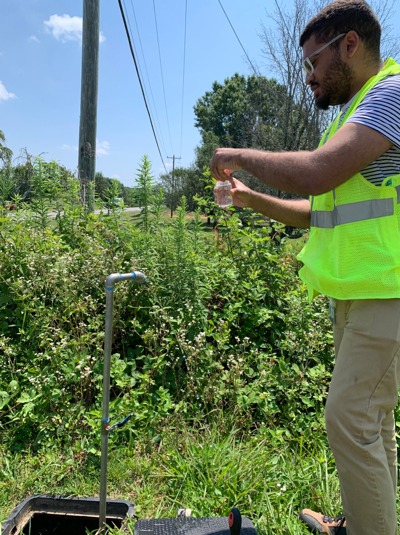 LaRon taking a drinking water sample from a sampling site to test it for coliform bacteria. 