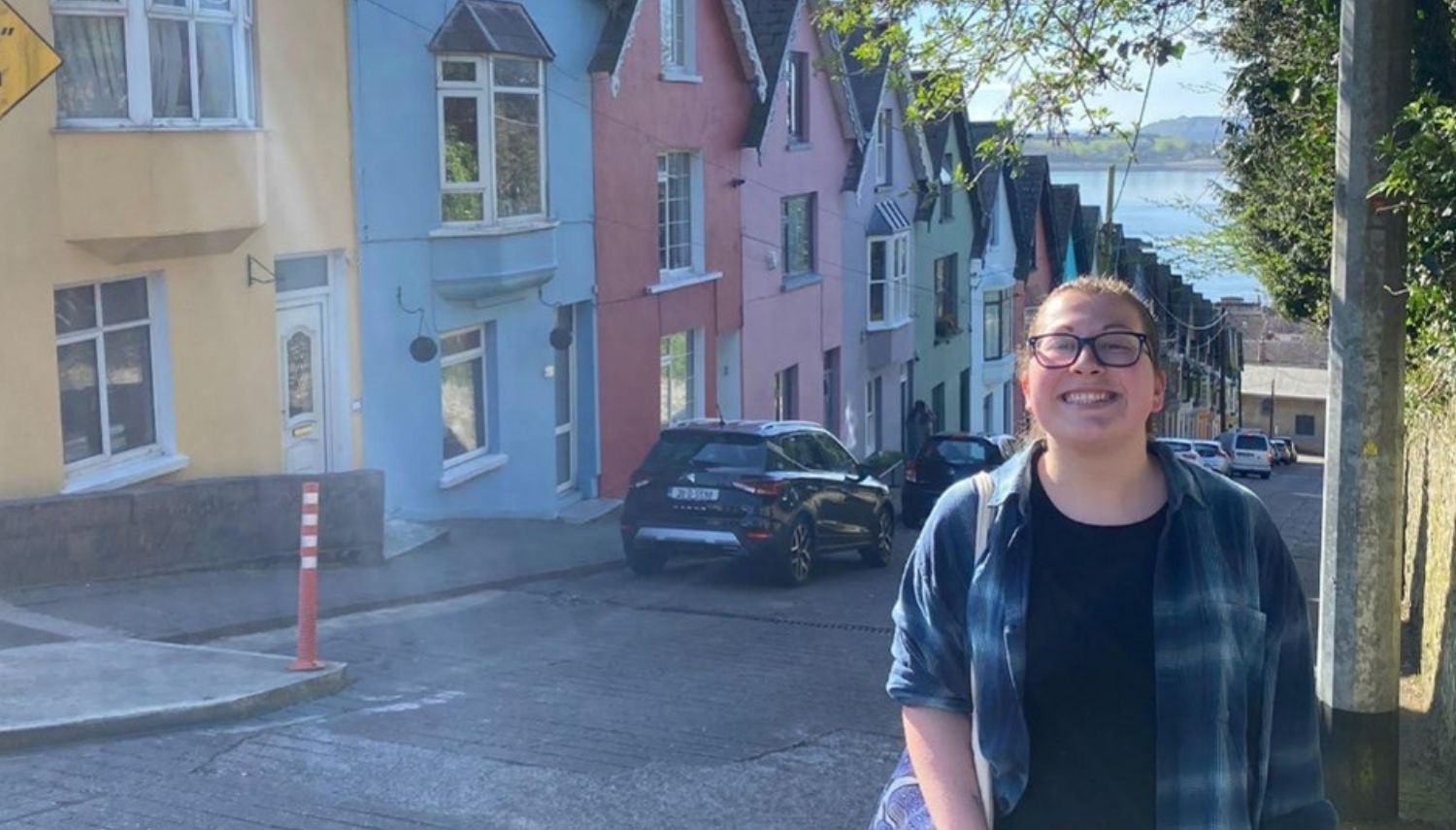Kendra standing on a street in Cobb, Ireland with colorful buildings behind her - Kendra Familette’s Semester in Ireland - Department of Forestry and Environmental Resources at NC State