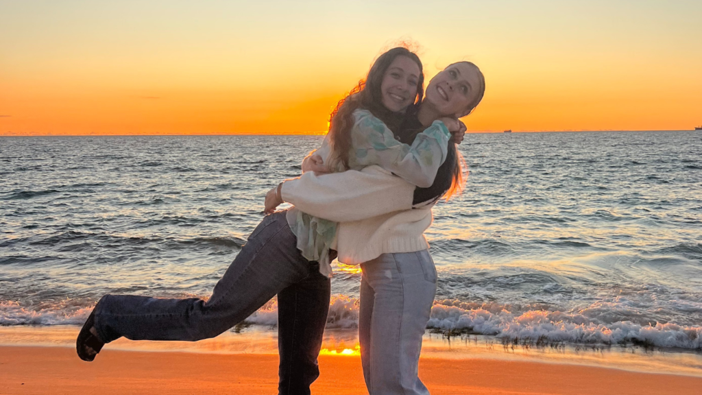 Tatiana and her Aussie friend, Georgia, standing on a beach the ocean and glowing sunset in the background- Tatiana Frontera’s Semester in Australia - Forestry and Environmental Resources at NC State University