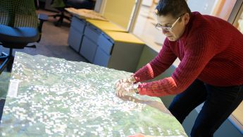 A photo of a man using a modeling tool at the North Carolina State University Center for Geospatial Analytics