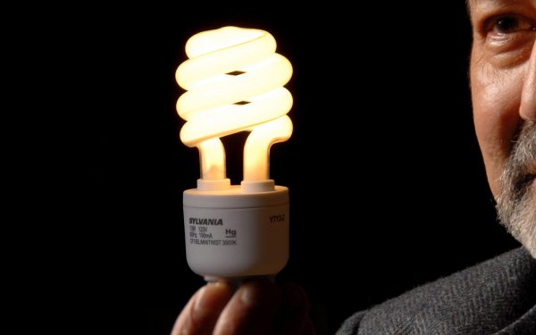 A photo of a man holding a CFL lightbulb