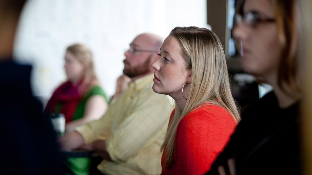 A woman listening to a lecture at the North Carolina State University Center for Geospatial Analytics
