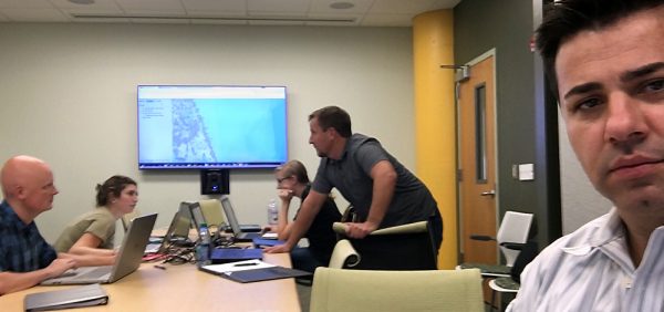 Okan Pala looks on as students collaborate during a simulated drill in a disaster management class at the North Carolina State University Center for Geospatial Analytics