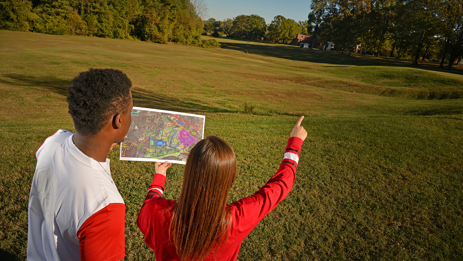 A photo of two students using a map outdoors