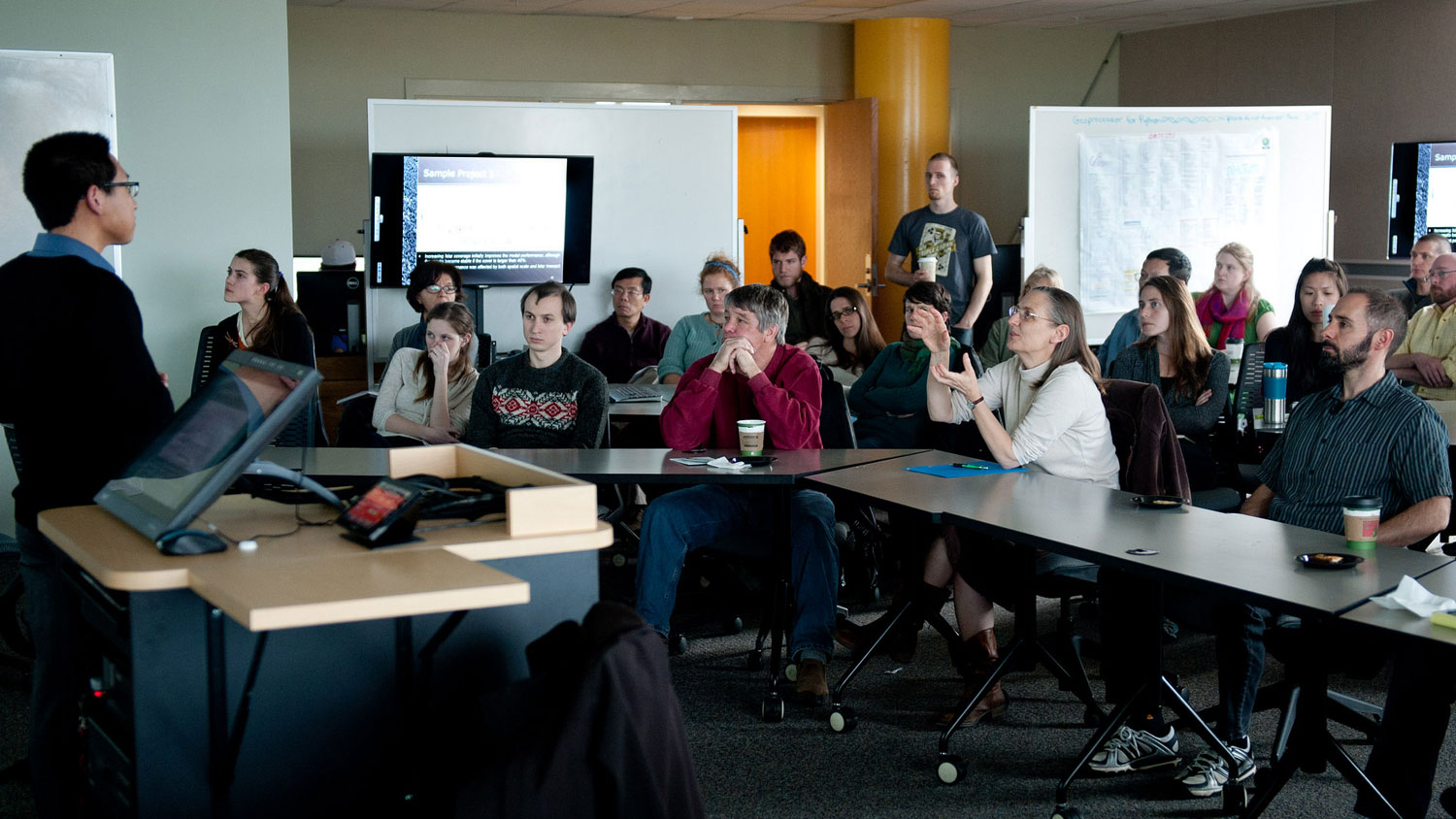 A photo of an audience at a presentation in an experimental classroom at the North Carolina Center for Geospatial Analytics