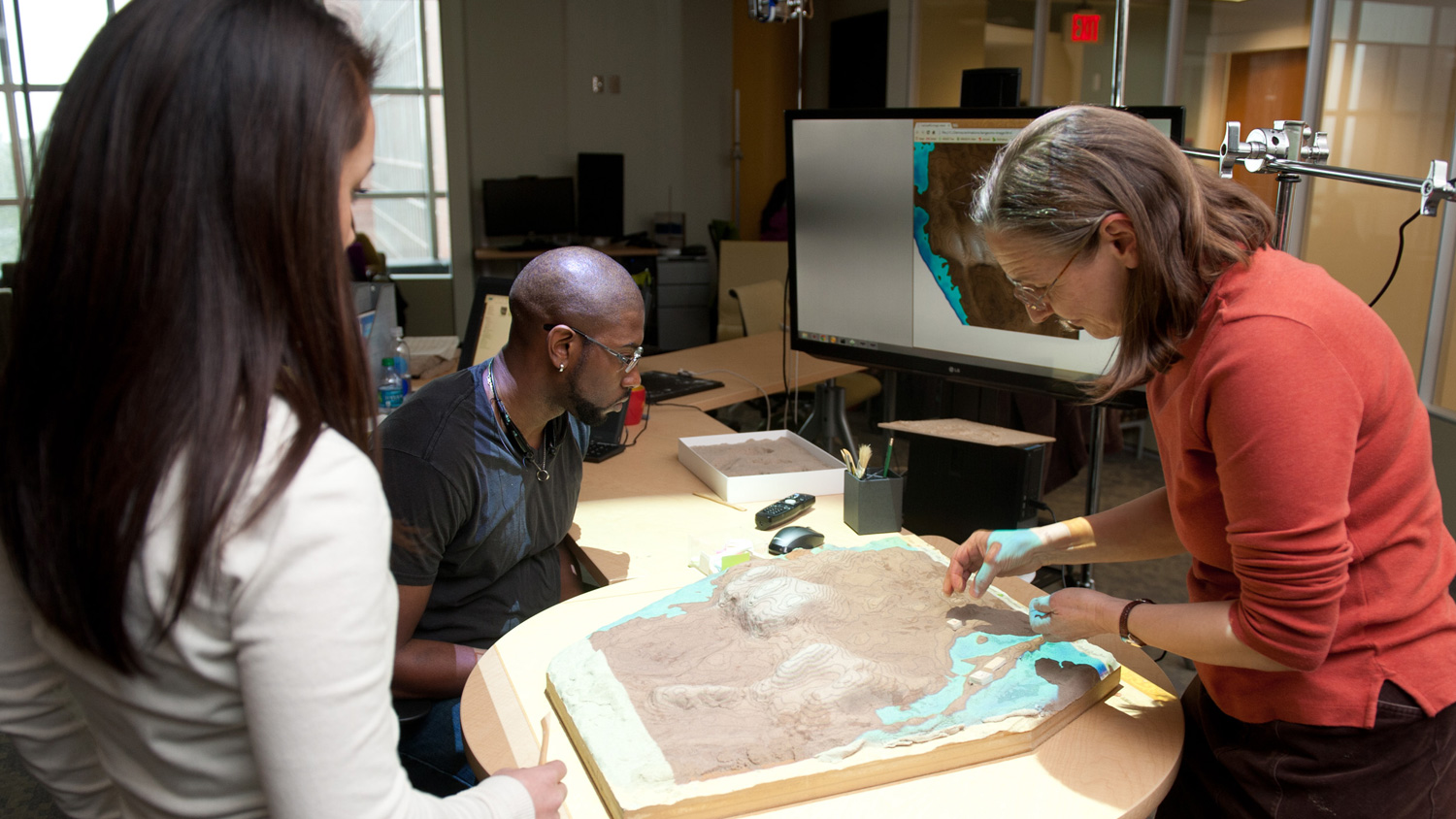 A photo of scholars using the Tangible Landscape at the North Carolina Center for Geospatial Analytics