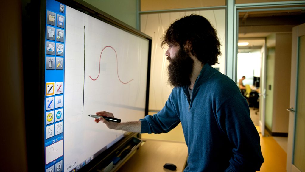 A photo of a student drawing on a touchscreen at the North Carolina State University Center for Geospatial Analytics