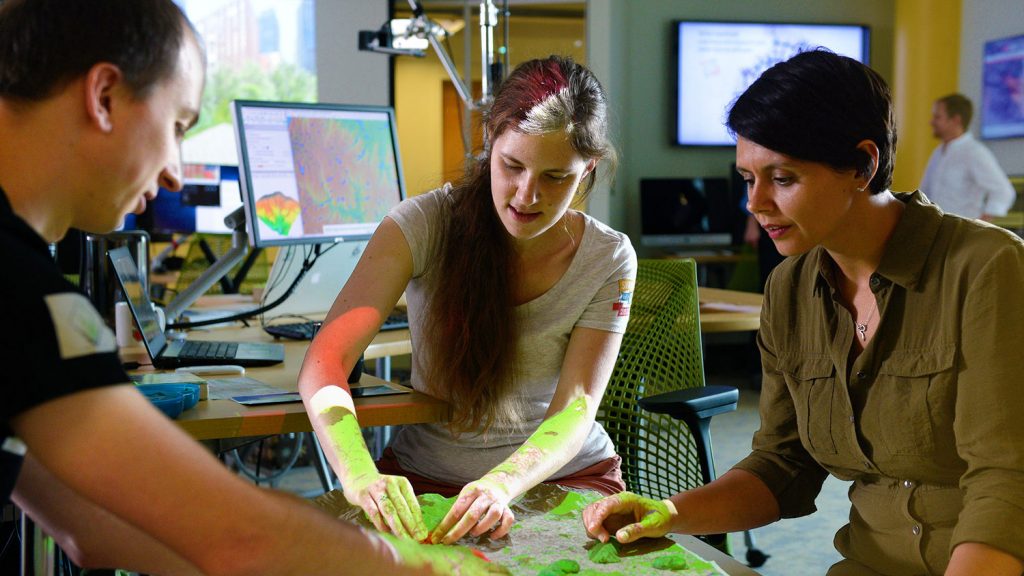 A photo of people using the Tangible Landscape at the North Carolina State University Center for Geospatial Analytics