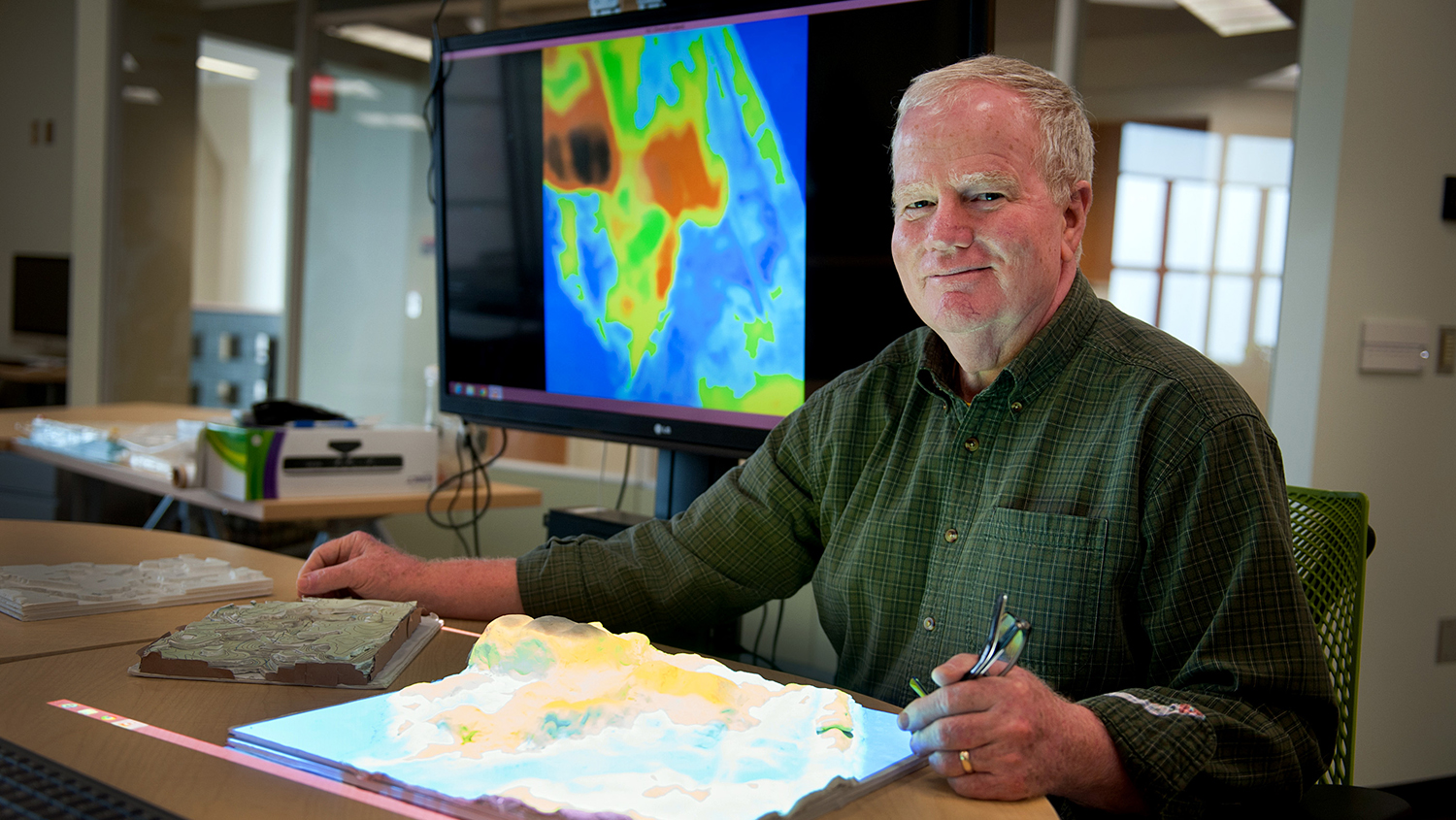 A photo of Hugh Devine using the Tangible Landscape at the North Carolina State University Center for Geospatial Analytics