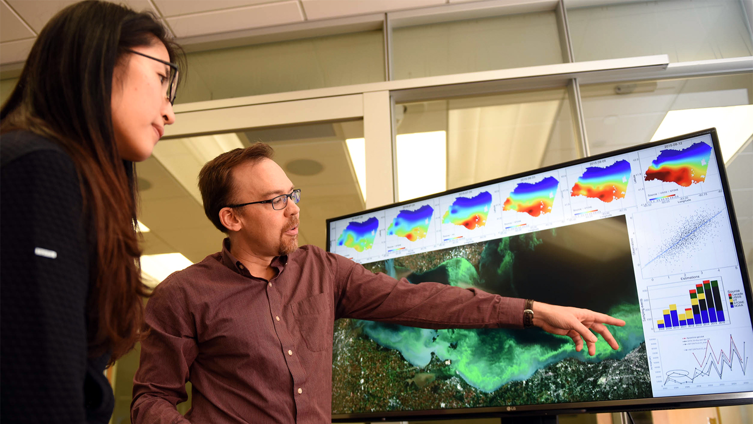 Dan Obenour points out an algal bloom on a screen to a student