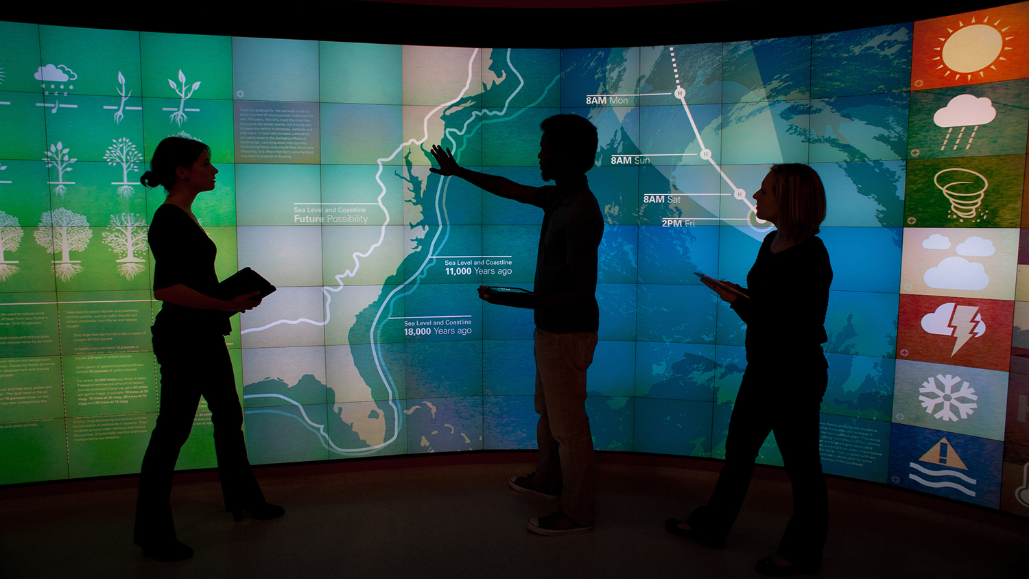 photo of students in front of graphics wall in Hunt Library. - Center for Geospatial Analytics at NC State University