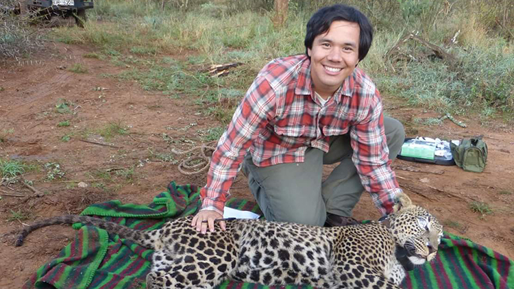 Student working in field with leopard