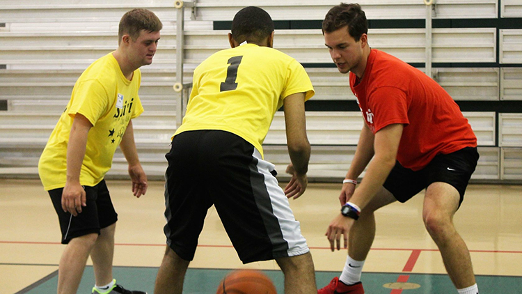 Student coaching players with special needs in basketball