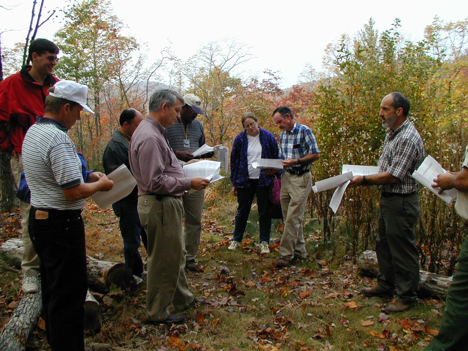 An extension agent reviews landscaping plans with a group of foresters. 