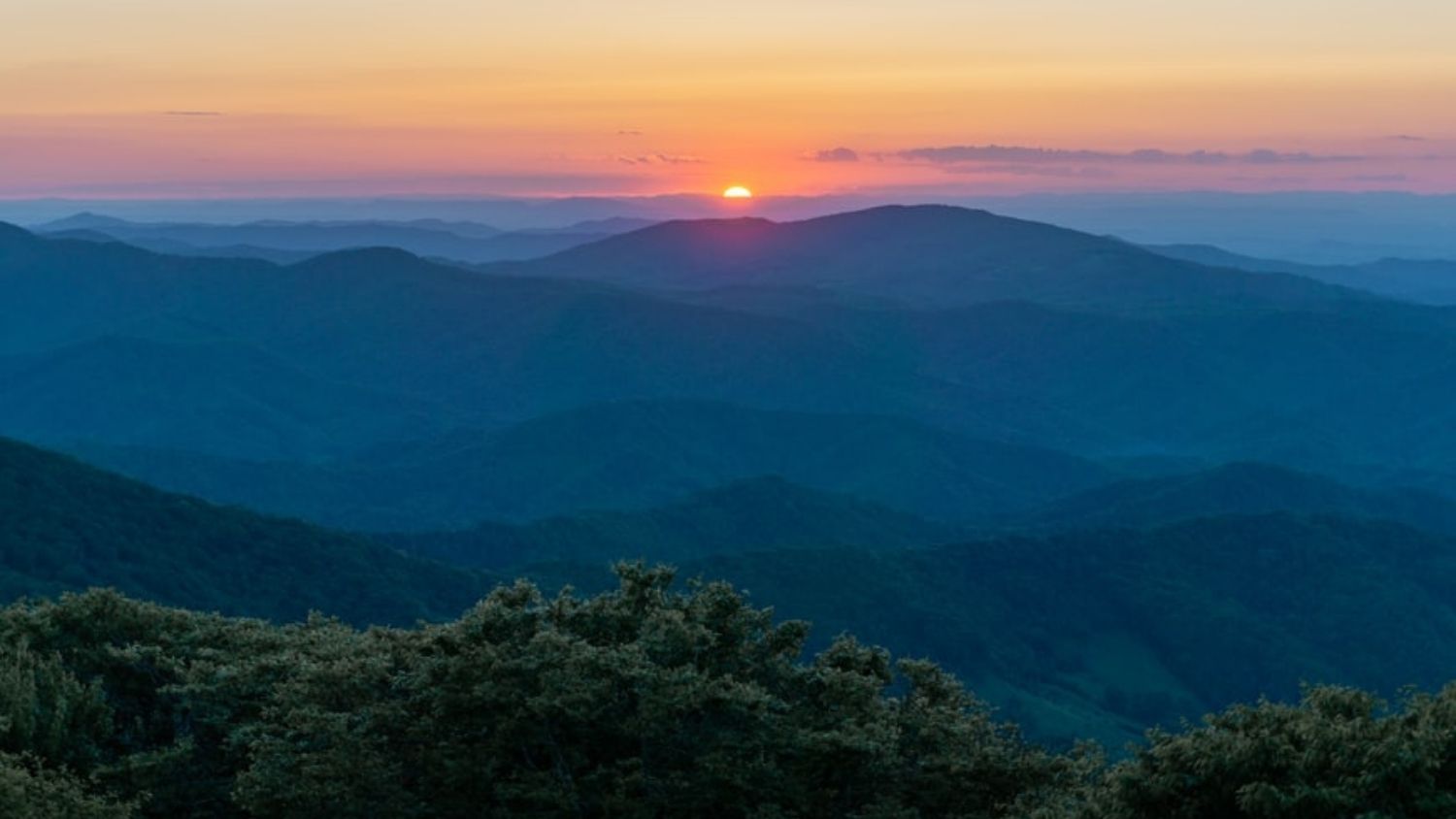 Sunset over tree-covered mountains - Nature Gap: Why Outdoor Spaces Lack Diversity and Inclusion -College of Natural Resources News NC State University