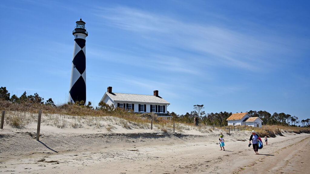 Visitors walk down the beach on Cape Lookout.