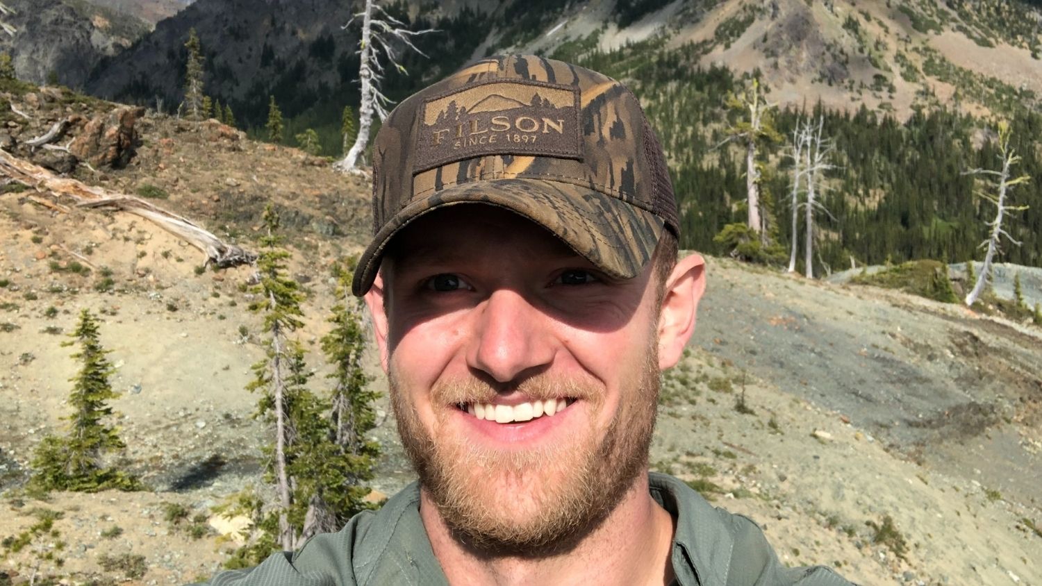 Trevor Setzer, smiling, hiking in the mountains