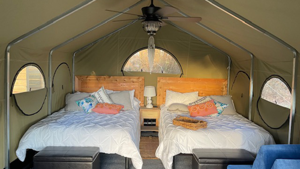 Inside of Glamtopia tent; Showing two beds and a ceiling fan.