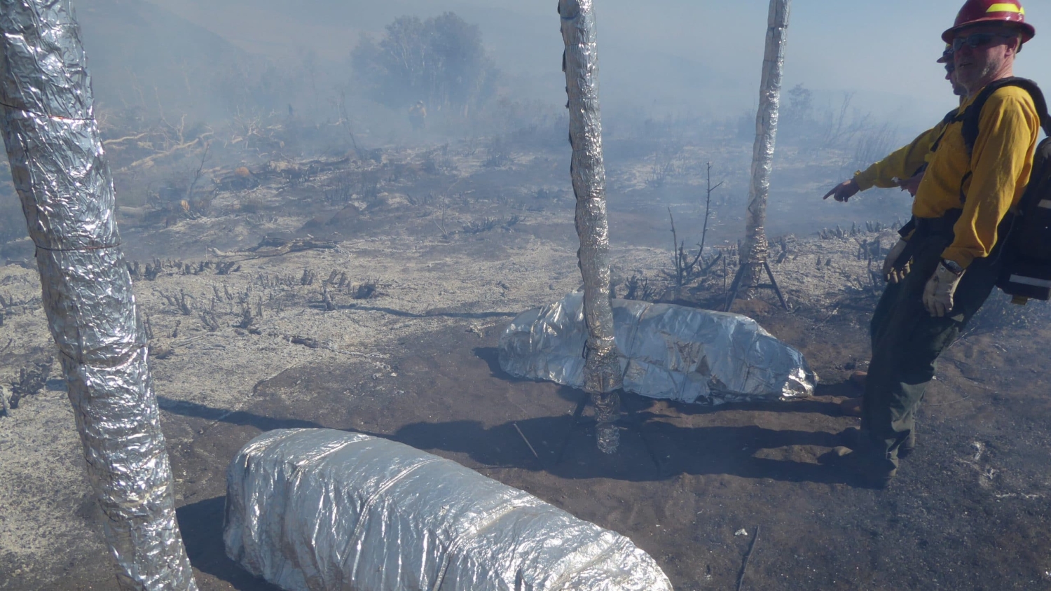 A firefighter points at a fire shelter new