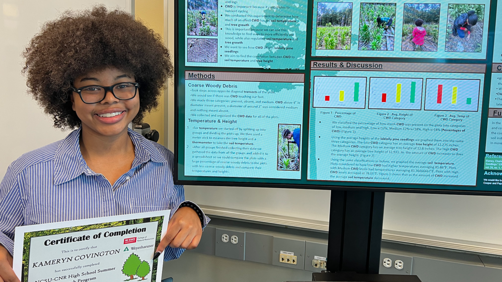 Kameryn Covington, one of the 12 students to participate in the summer program, showcases her certificate of completion after presenting her research on coarse woody debris.