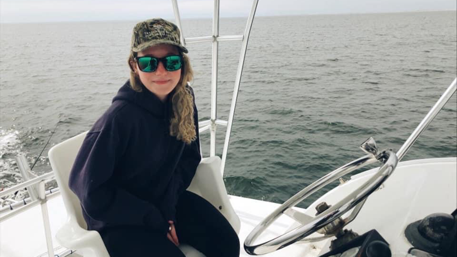 Ivy Cage sits in fishing boat - Ivy Cage '26 Recognized for Oyster Reef Restoration Efforts - College of Natural Resources News NC State University