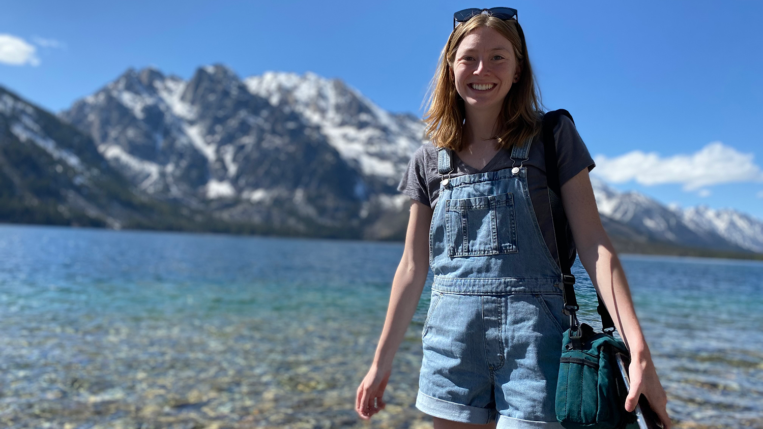 Julianne Reas stands on a lakeshore in front of a mountain - 5 Questions with Global Change Fellow Juulianne Read - College of Natural Resources News NC State University