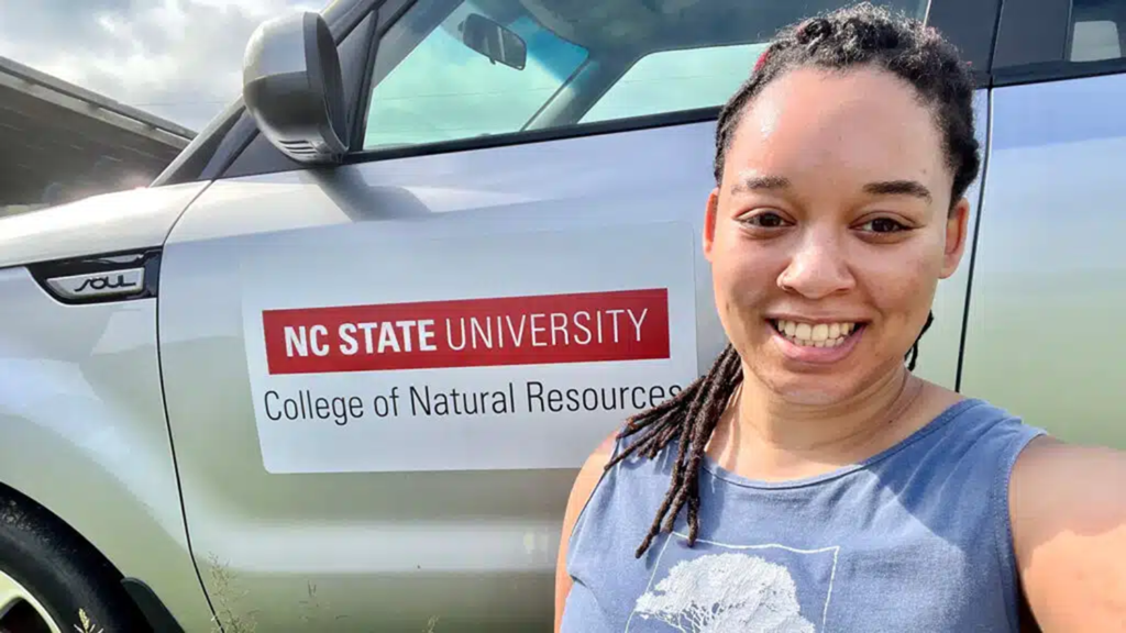NC State student Murry Burgess showcasing a car magnet with the College of Natural Resources logo