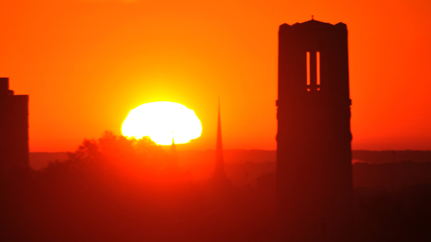 A view of the NC State belltower during sunset - Industry Partnership to Assess Climate Change Risks - College of Natural Resources News NC State University