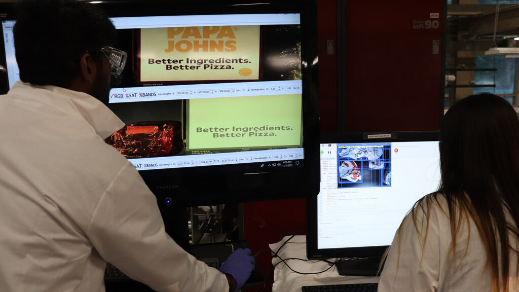 Two researchers looking at a computer monitor.