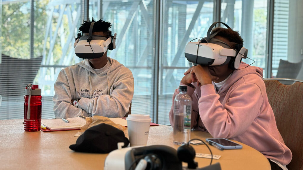 Two people wearing virtual reality goggles.