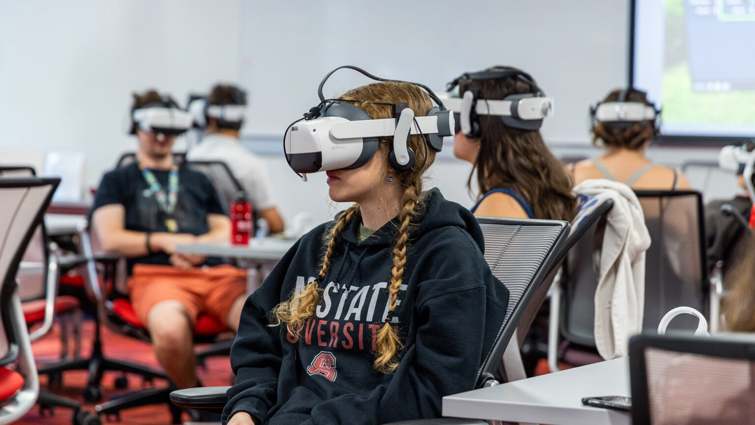 A student in a classroom wears a virtual reality headset.