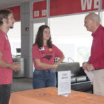 Two students talk with a donor