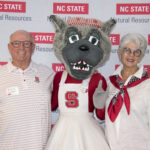 A couple poses with Mrs. Wuf