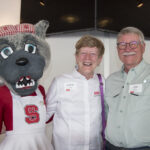 A smiling couple poses with Mrs. Wuf