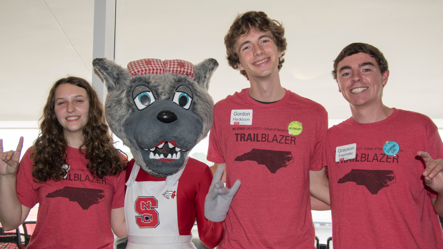 Three scholarship students pose with Mrs. Wuf