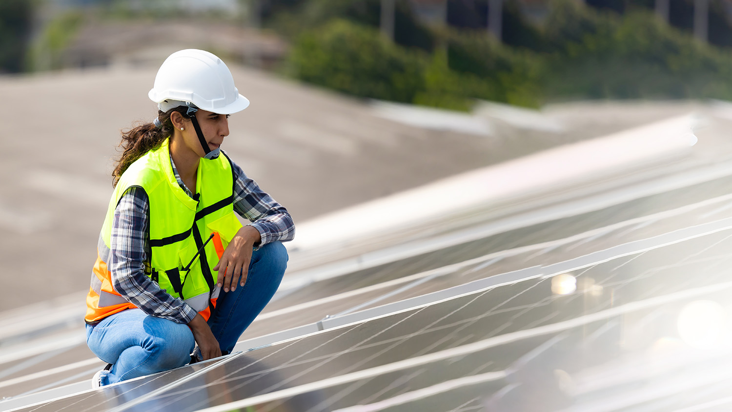 Female worker inspects solar panels.