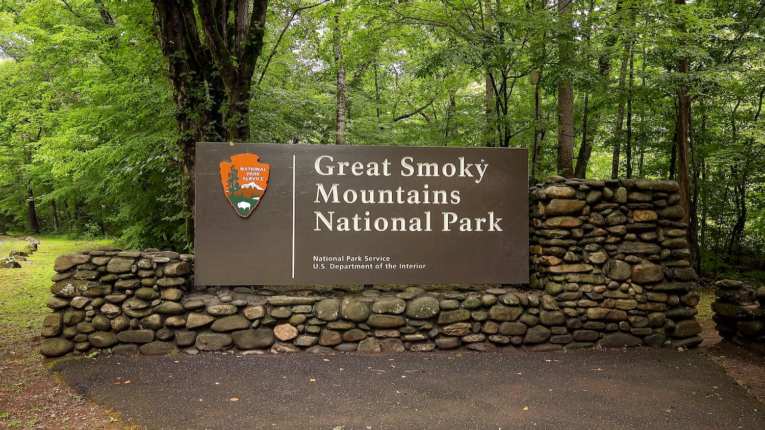 Great Smoky Mountains National Park entrance sign in forest.