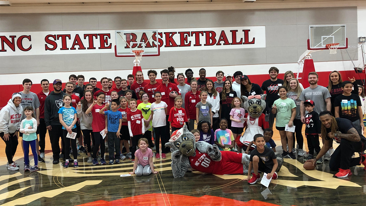 Dillard Drive and NC State students pose for group photo on basketball court