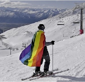Skier with pride flag as a cape.