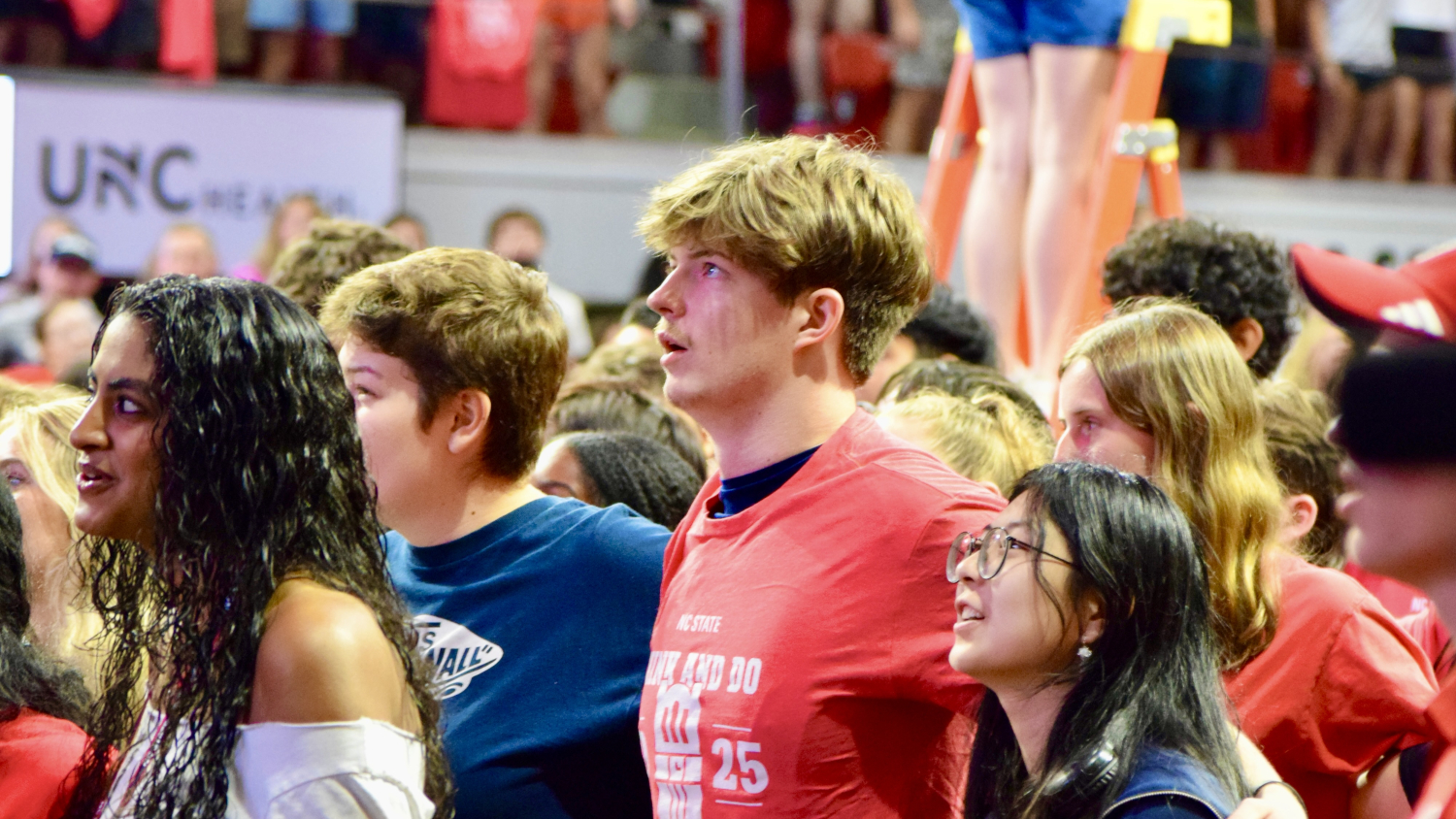 Students stand together arm-in-arm as they look up in wonder at the New Student Convocation. - Admissions - College of Natural Resources at NC State