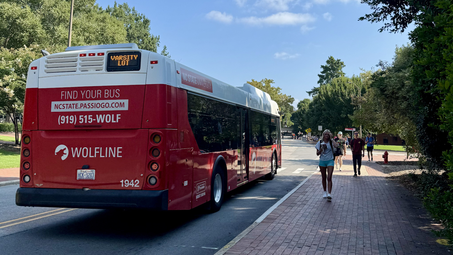 The Wolfline bus passes by as students walk to class on a sunny morning. - Admissions - College of Natural Resources at NC State