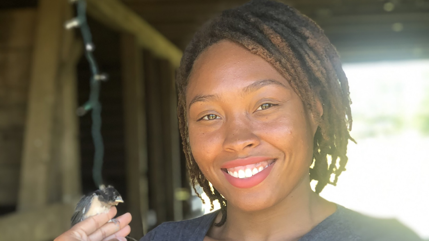 Deja Perkins with Barn Swallow bird - Graduation to Vocation: Connecting Environmental Justice and Birding - College of Natural Resources NC State University