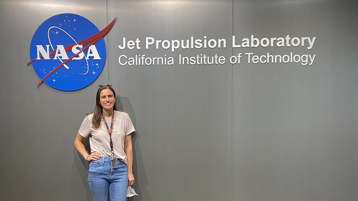 NC State student poses in front of the NASA logo at the Jet Propulsion Laboratory headquarters in Pasadena, California